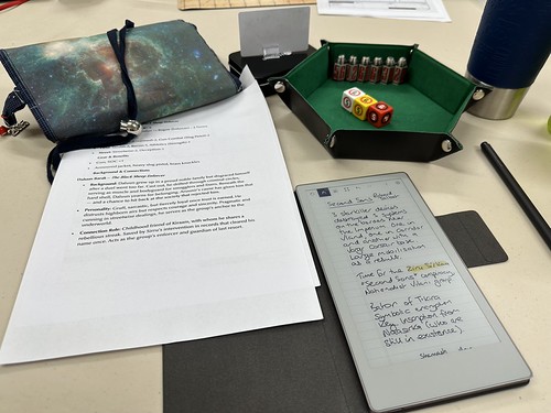 Another table photo from TravCon 2025 - this time with my Second Sons character, scenario notes on a reMarkable Move and dice bag and dice tray with the bullet dice out.